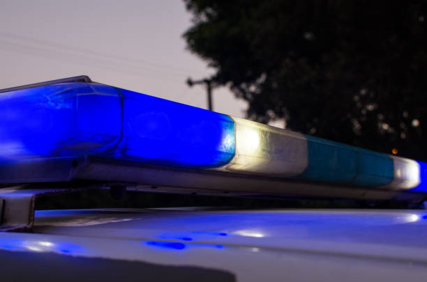 Police car with blue lights on the crime scene in traffic urban environment.