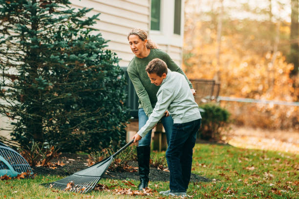 istock Mother And Son Raking Autumn Leaves 1192119670