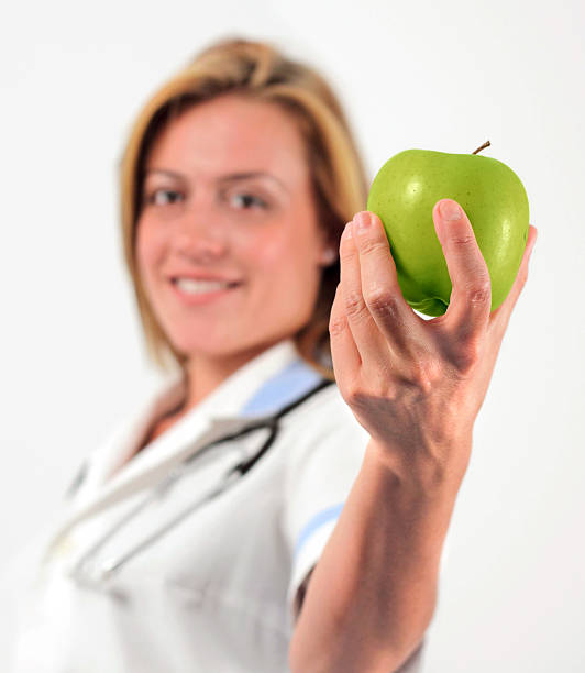 istock young doctor holding an apple 119212346