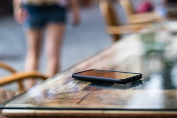 Lost smart phone on table at outdoor cafe. Selective focus