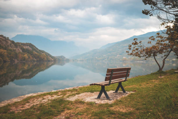 Lago di Cavedine beautiful lake. Wooden bench in focus. Italy. Arco