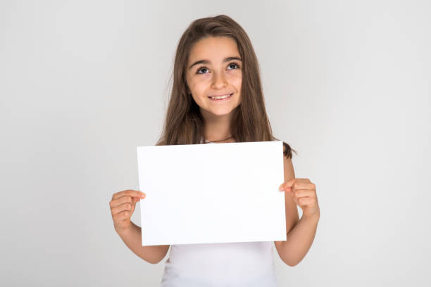 istock Little girl holding blank white paper 1192130244