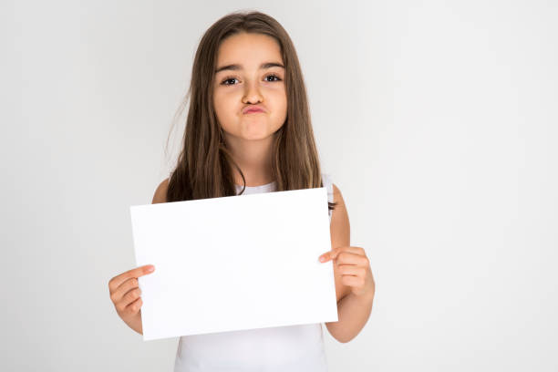 istock Little girl holding blank white paper 1192130295