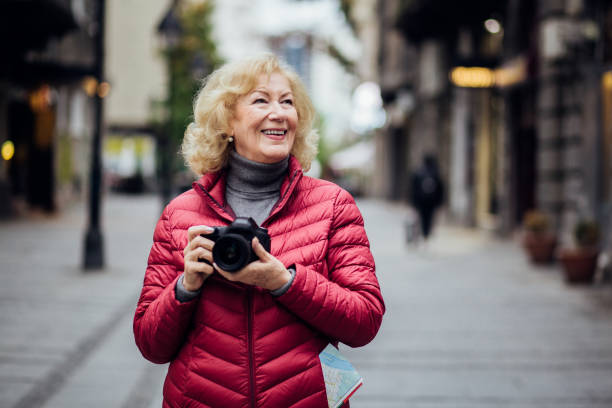 istock Older tourist holding photo camera 1192130427