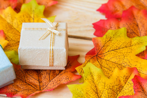 maple leaf and mini gift box with wooden background.