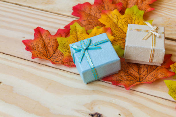 istock maple leaf and mini gift box with wooden background. 1192131205