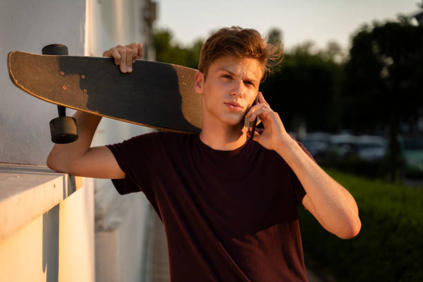 istock Portrait of handsome millennial holding longboard 1192133609