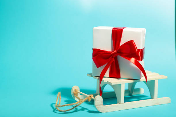 istock White sleigh with gift on blue background with copy space 1192135017