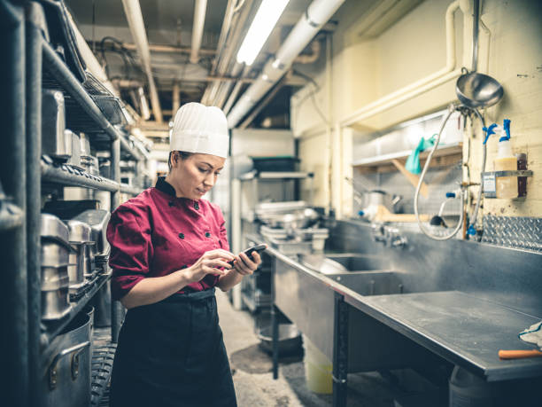 istock Female Chef with mobile phone 1192135133