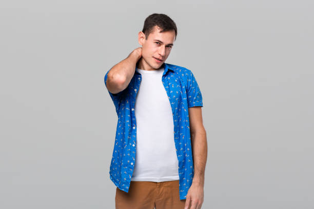 istock Unsure man stroking neck expressing doubtful emotion isolated over grey background 1192135317