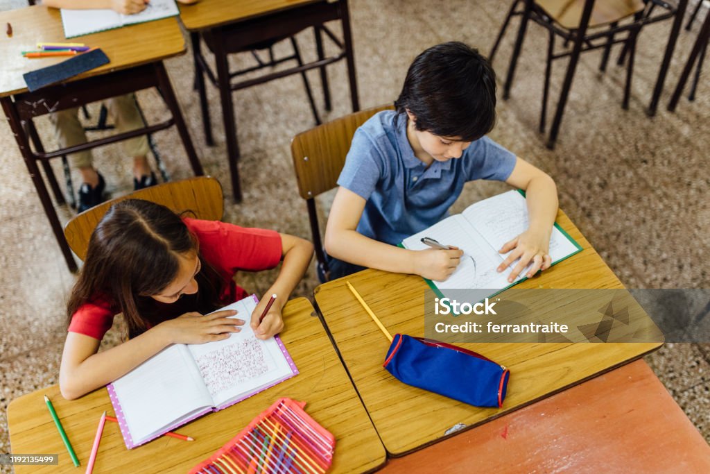 Student Writing In Notebook Elementary School Students Writing In Notebook Stock Photo - Download ...