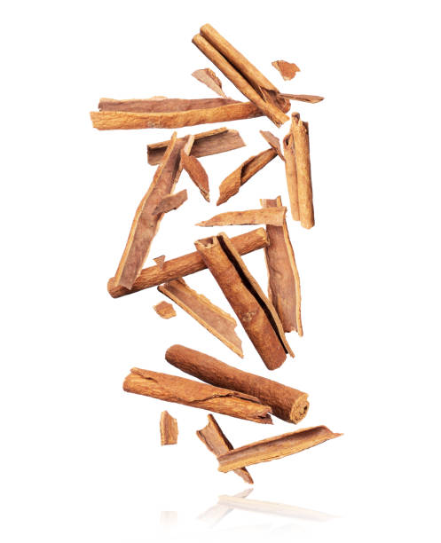 cinnamon sticks are falling down in chaotic order on a pile on a white background - canella imagens e fotografias de stock