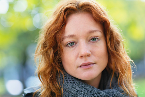 Close up portrait of young woman with a serious look outdoors.