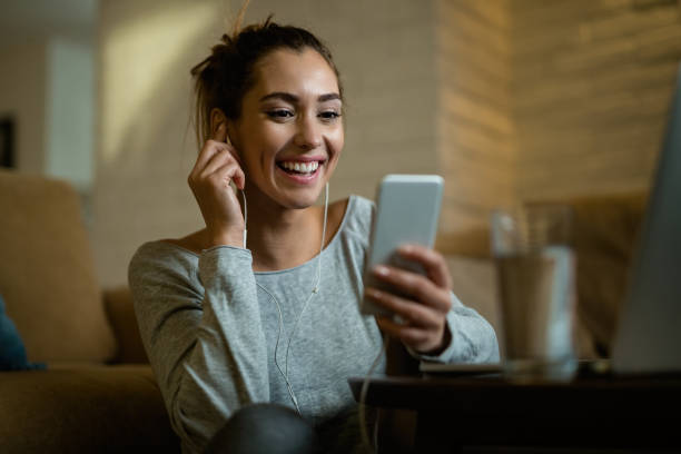 istock Happy woman reading text message on cell phone while relaxing at home. 1192143713