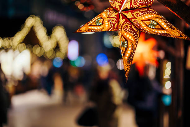 bunte sterne auf weihnachtsbaum auf weihnachtsmarkt in hamburg beleuchtet - christkindlmarkt stock-fotos und bilder