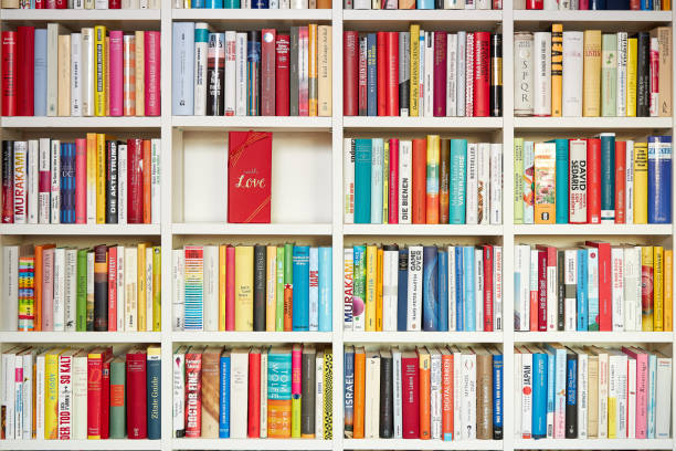 istock Library, white shelves, multi colored books,  one part filled with red gift wrap, with love 1192144868