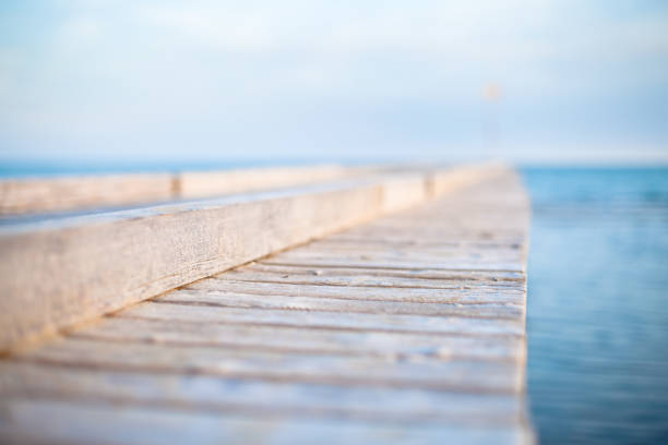 Wooden deck by the sea Wooden deck by the sea in a calm sunny day cielo minaccioso stock pictures, royalty-free photos & images