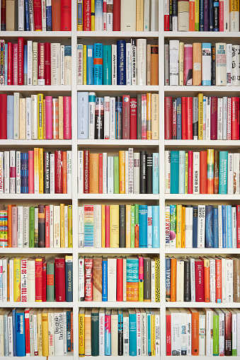 Library, white shelves, multi colored books