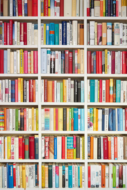 Library, white shelves, multi colored books stock photo