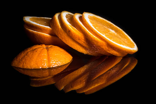 istock Fresh organic orange fruit, sliced, with reflection on shiny black background 1192146962