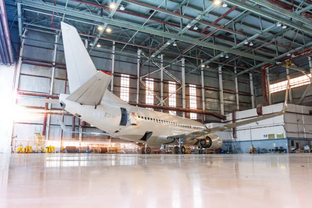 istock White passenger airplane in the hangar at the morning light. Checking mechanical systems for flight operations. Aircraft under maintenance 1192148119