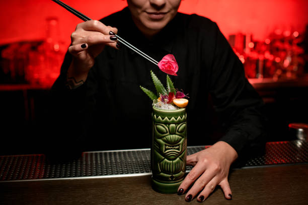 istock Close-up of bartender decorating cocktail with flowers 1192148235