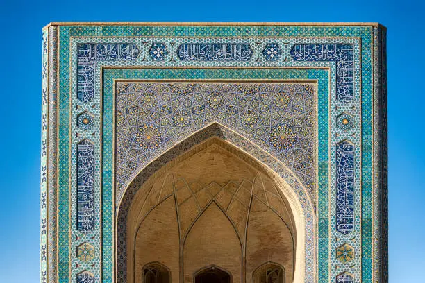 Main entrance of the Kaylan mosque (right, 16th century) in Bukhara, Uzbeksitan. The center of Bukhara (also calloed Buchara or Buxoro) is listed as UNESCO World Heritage Site. Bukhara was one of the most important oasis and place of caravanserais at the Great Silk Road.