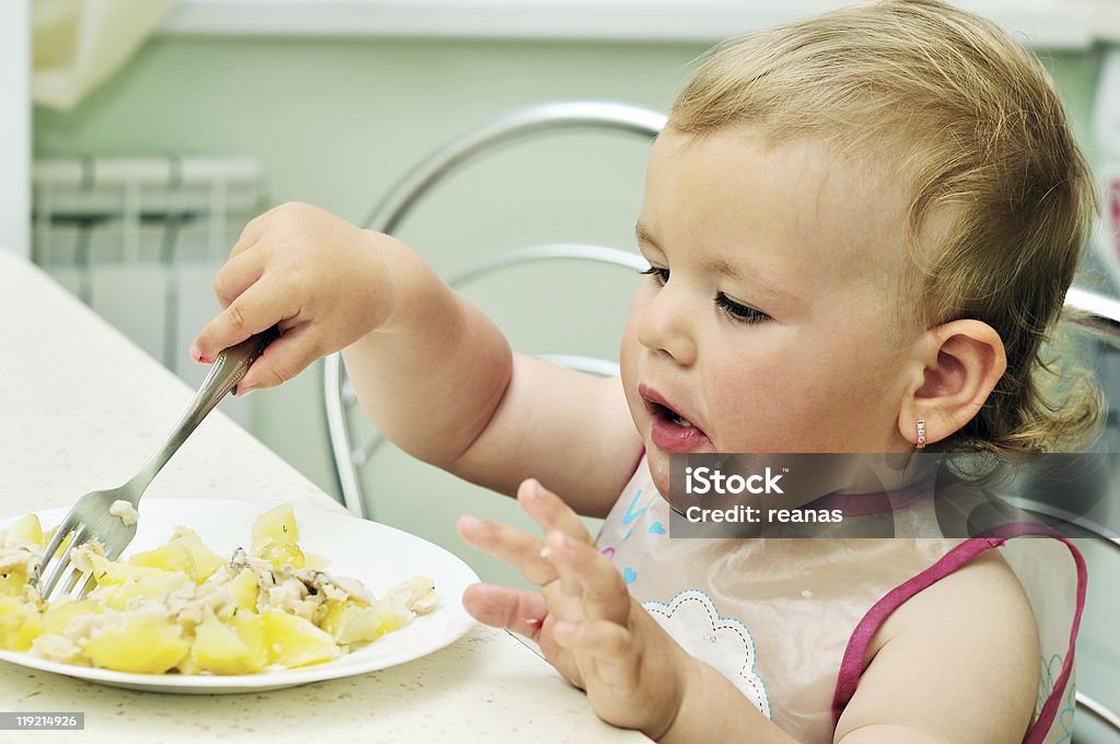 baby girl   eating with fork  Beautiful People Stock Photo