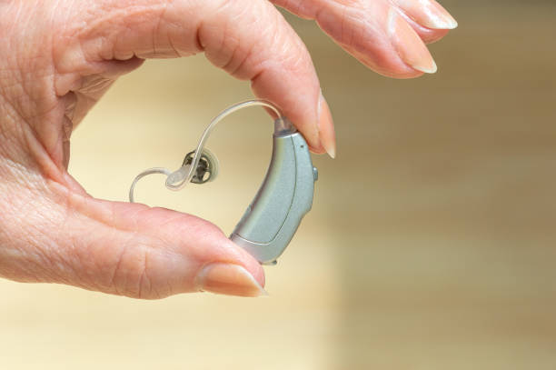 hearing aid device in hand isolated on white background