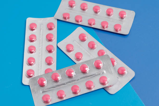 istock Blister rose capsule on blue background, medical pharmacy concept 1192149759