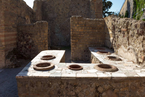 Thermopolium in taberna in Ancient Ercolano (Herculaneum) city ruins.  Naples, Campania, Italy