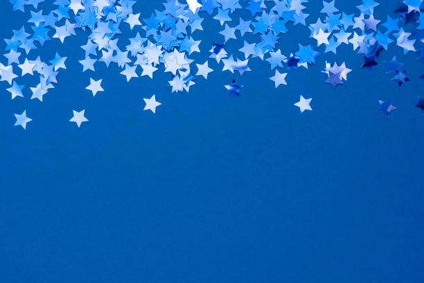 istock Blue abstract Christmas background or texture with stars confetti on blue background. Space for text. 1192150206