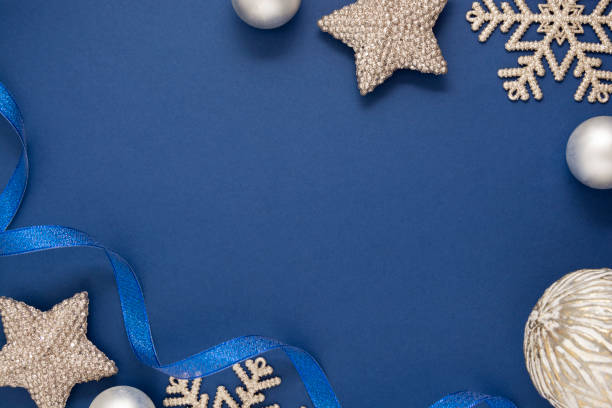 istock Blue abstract Christmas minimalistic styled background with silver snowflakes, baubles and blue ribbon. Blue mock up with space for text. 1192151177