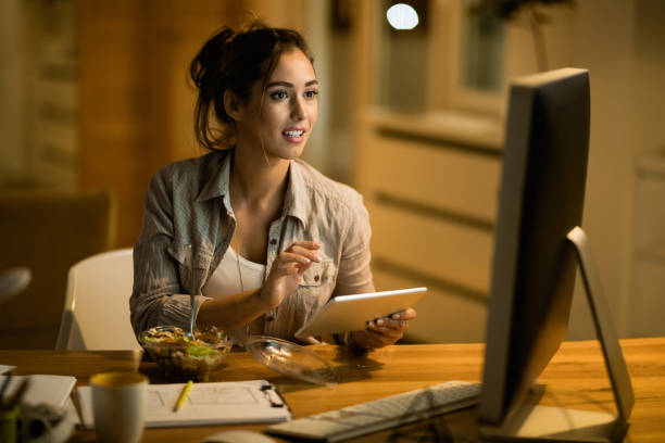 istock Young woman multi-tasking while working late at home. 1192151712