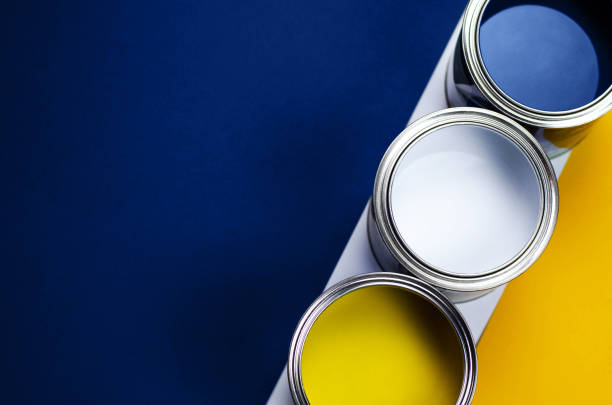 latas da pintura em um fundo do azul amarelo e clássico. - orange wall textured paint - fotografias e filmes do acervo