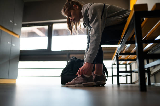 istock Young woman preparing for training in locker room 1192154083