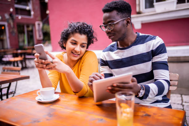 istock Young couple at a coffee shop looking at a digital tablet 1192154216