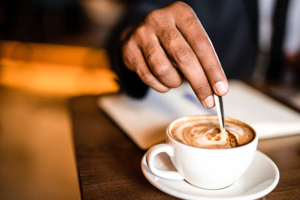 uomo d'affari che mescola la mano del caffè da vicino. - mescolare foto e immagini stock