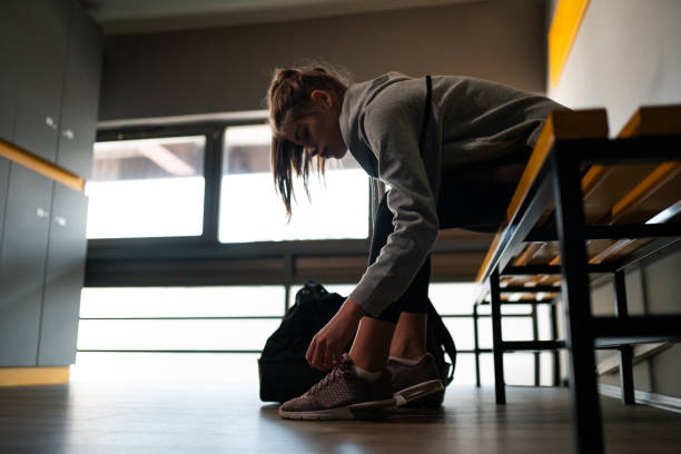 istock Young woman preparing for training in locker room 1192155221