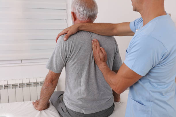 senior man with back pain. spine physical therapist and paient. chiropractic pain relief therapy. - osteoarthritis doctor medicine healthcare and medicine imagens e fotografias de stock