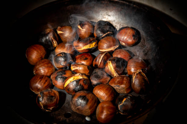 castañas asadas en sartén casera - chestnut roasted heat roasted chestnut fotografías e imágenes de stock