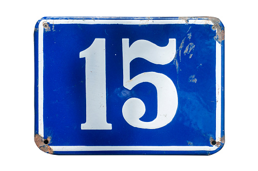 Weathered grunge square metal enameled plate of number of street address with number 15 closeup isolated on white background