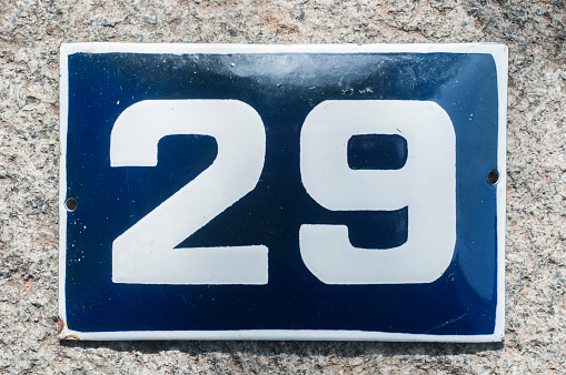 Number 13 is considered an unlucky number in many countries. Old-fashioned enamel sign on a green house wall.