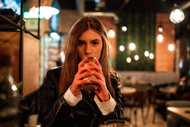Young beautiful woman sitting at cafe and drinking coffee