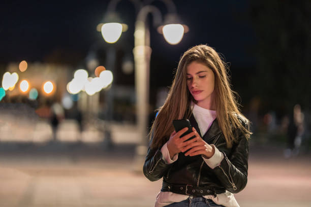 istock Young woman walking and using phone 1192164179