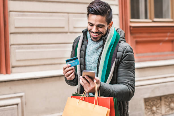 Portrait of a young man using credit card