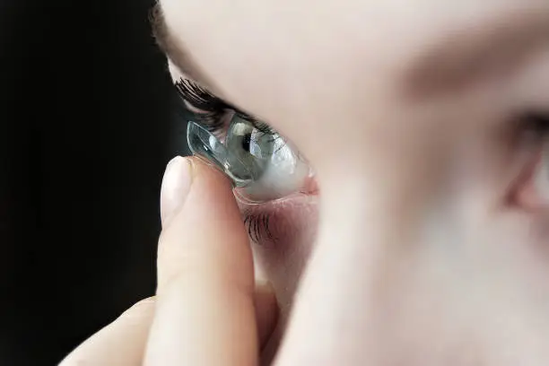 Photo of girl holding soft contact lenses