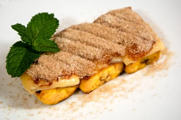 Photo of Delicious Brazilian dessert Cartola made with fried bananas, cheese and suggar with cinnamon.