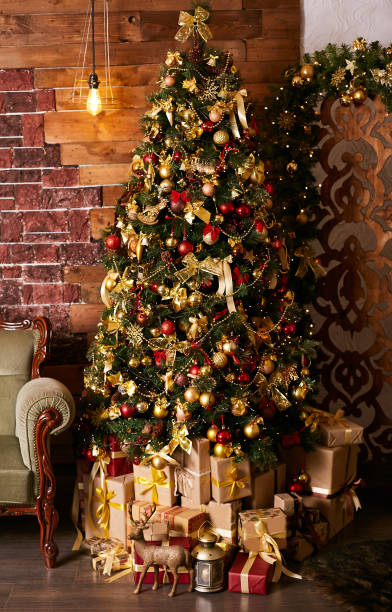 istock High beautiful Christmas tree in the home interior. Packed gifts under the tree 1192168050