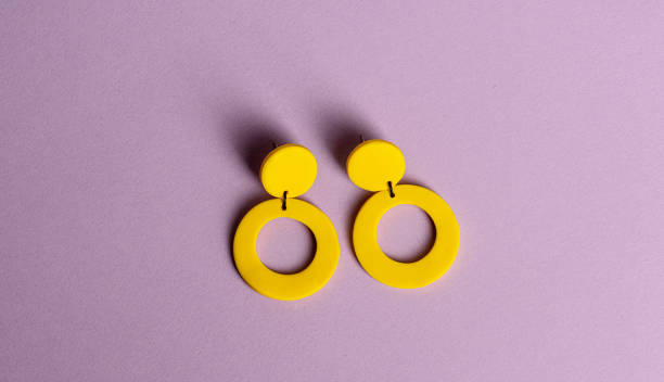 Yellow earrings on purple background.